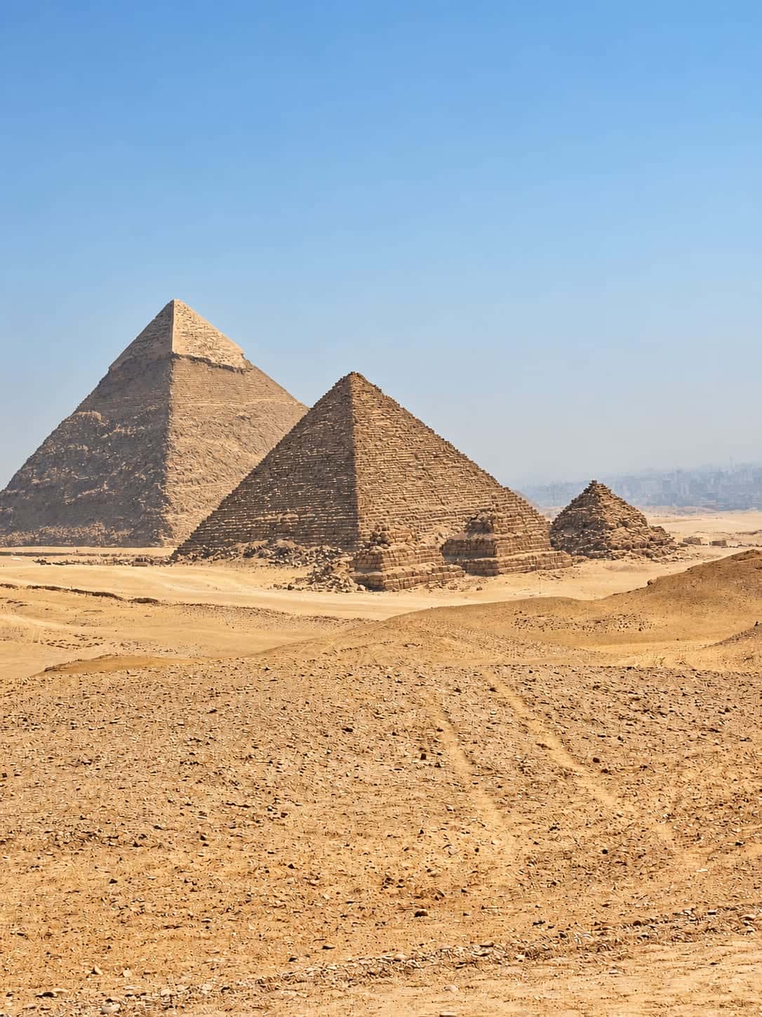 The pyramids of Giza rising above a broad sandy plateau in Egypt